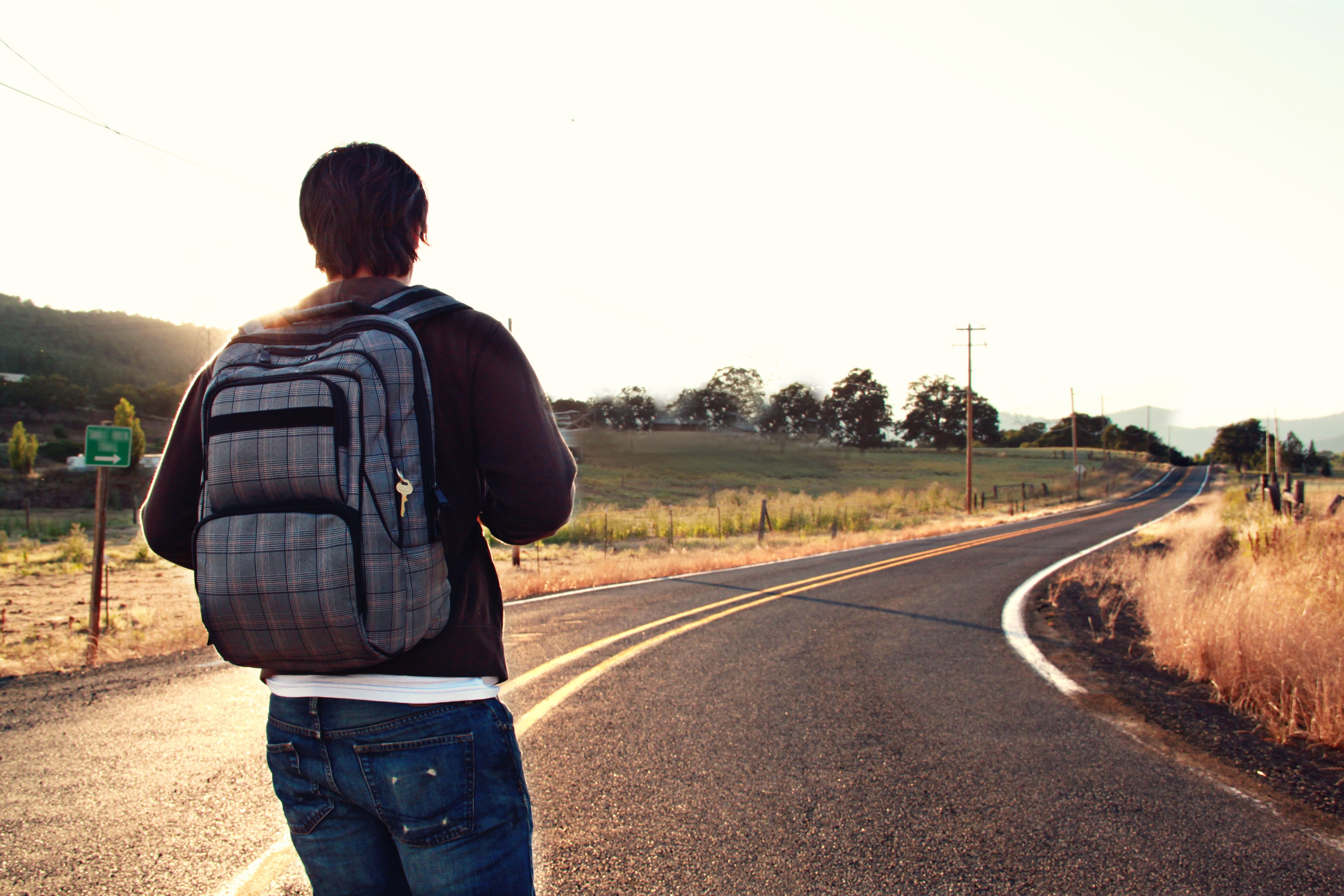 A man facing an open road about to embark on a new journey